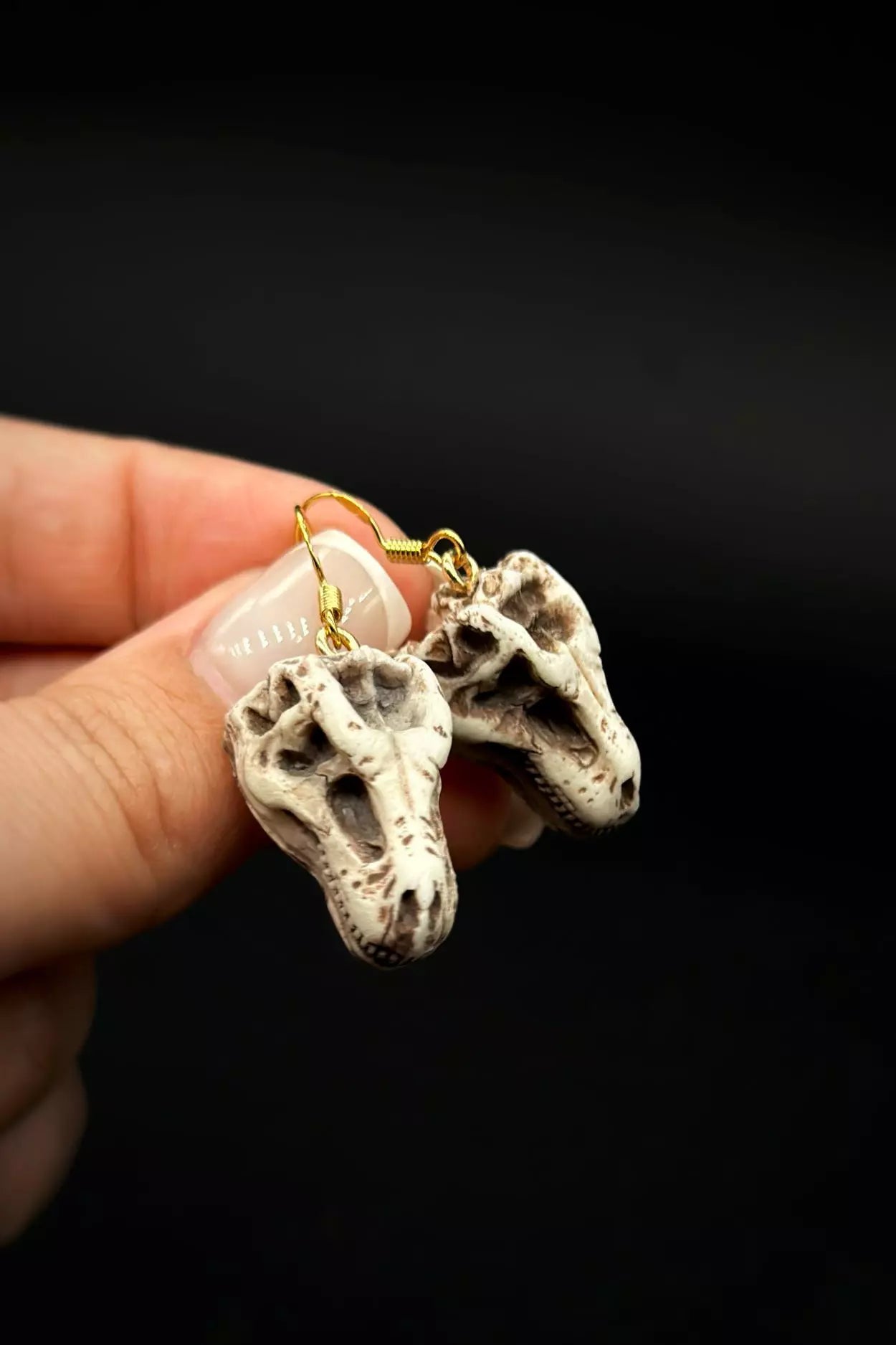 Trex Head Earrings in stud or dangle variations, featuring realistic dinosaur skull and skeleton designs by ioArtStudio